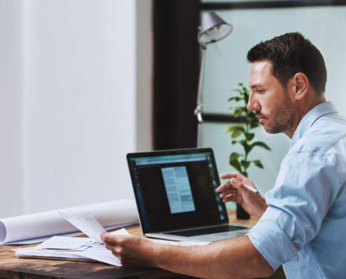 Architect, Planning And Online With Laptop For Man, Paperwork And Email For Research On Building